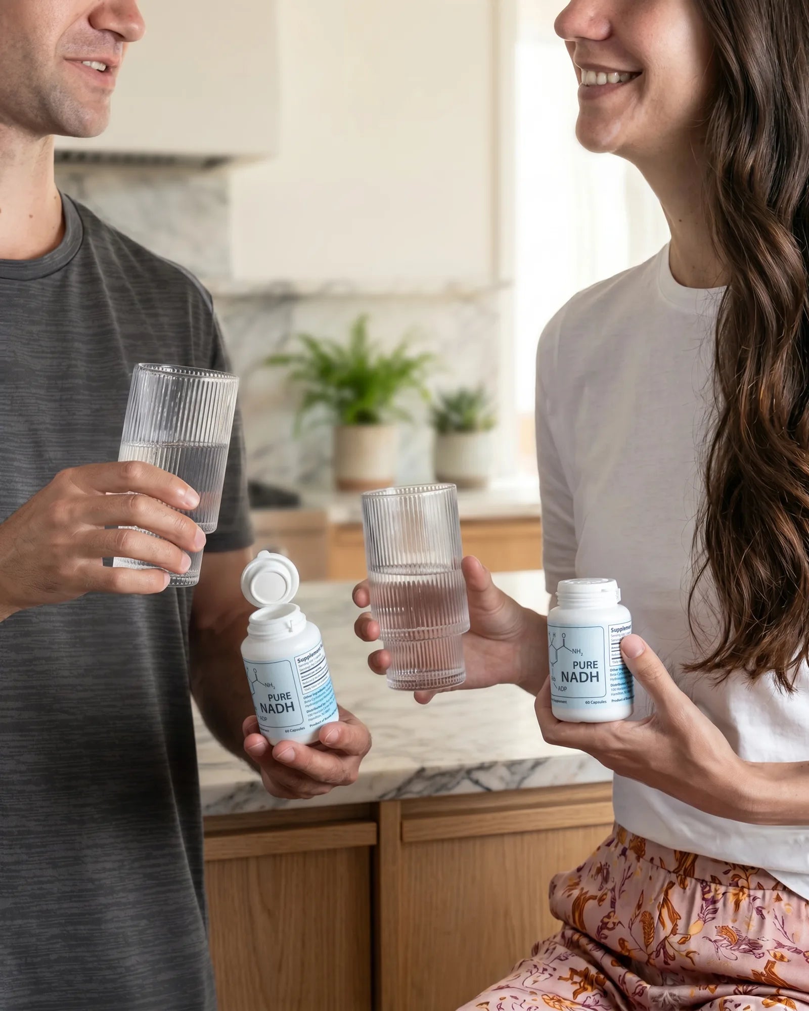 Couple starting the morning with PureNADH and glasses of water in the kitchen