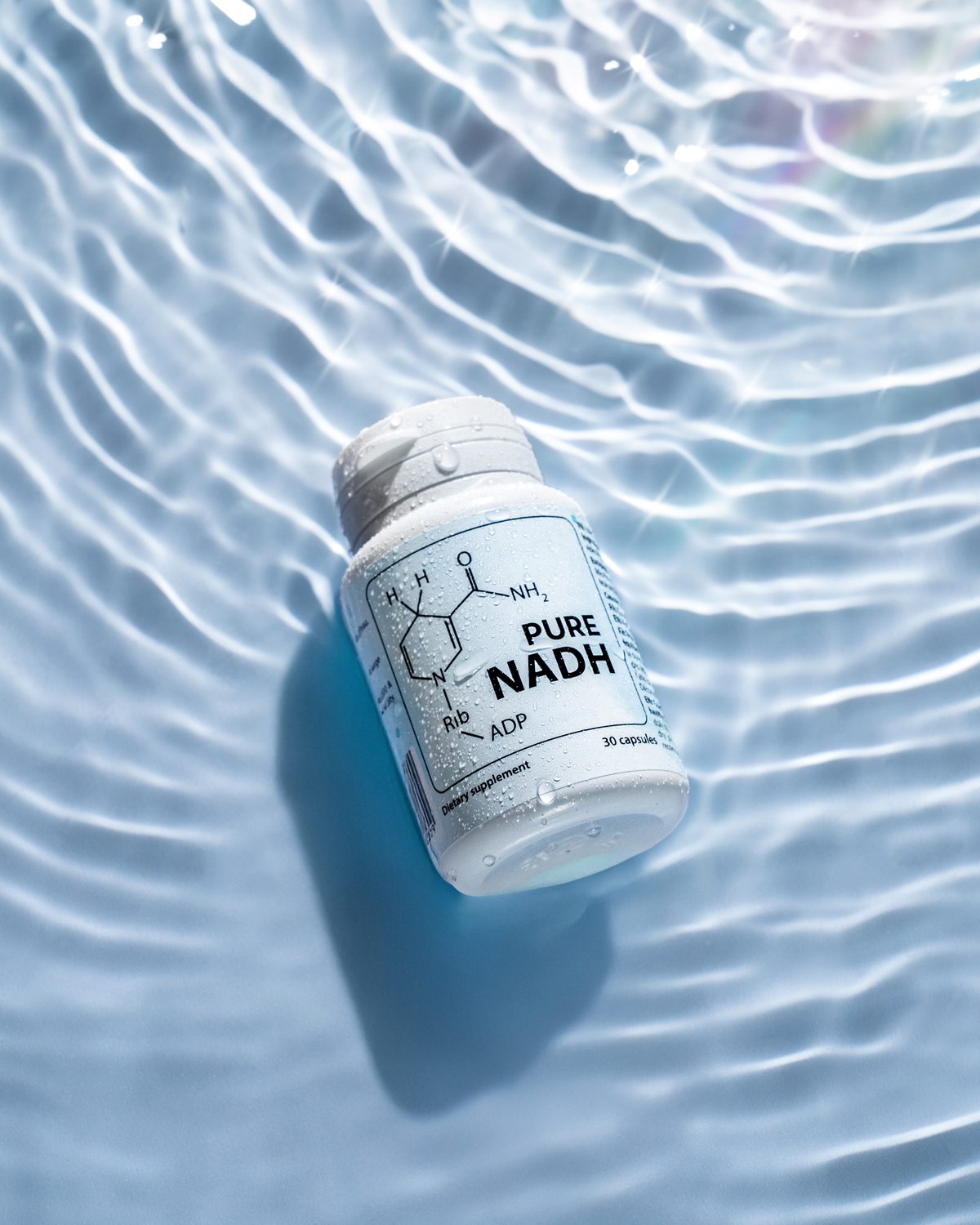 PureNADH bottle lying in clear rippled water
