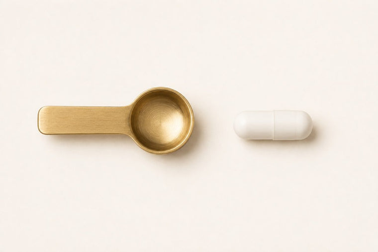 A small measuring spoon and one capsule on an ivory surface