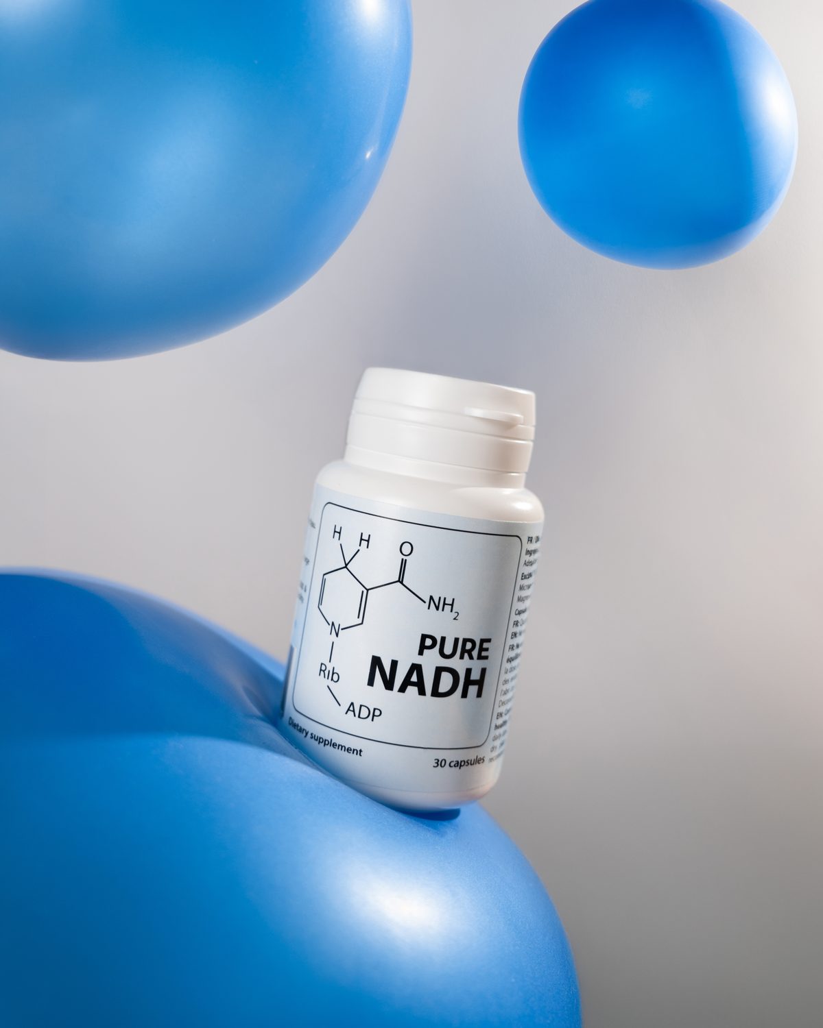 PureNADH bottle resting on blue balloons