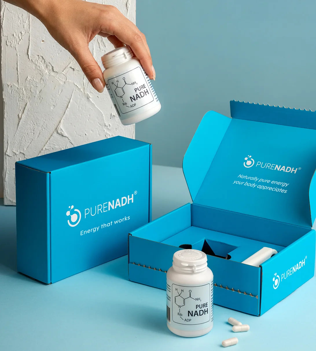 PureNADH 100mg NADH capsules with branded gift boxes and loose capsules on a blue background