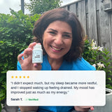Verified customer Sarah T. smiling outdoors holding PureNADH, five-star review about better sleep, mood and energy